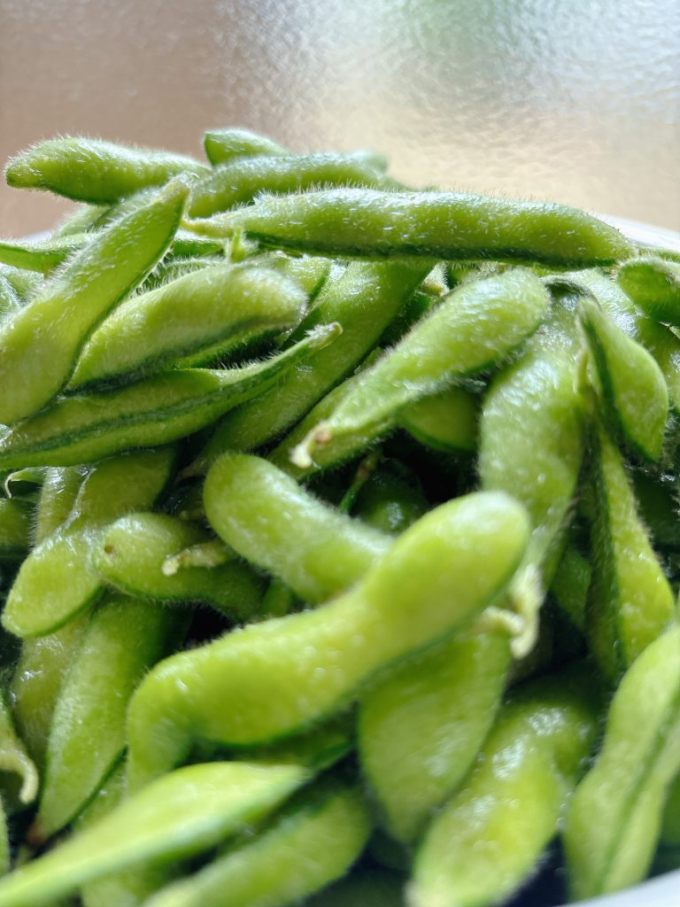 本物の枝豆がざっくりと置かれている様子。みずみずしく新鮮で、自然の豊かさを感じさせる。