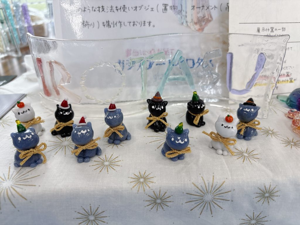 新しいガラス看板「IROTASU」と、ハロウィン風のミニ猫フィギュアが並ぶテーブル展示。
