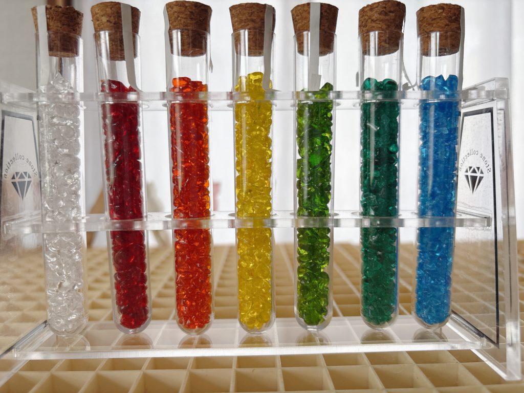 白・赤・橙・黄・黄緑・緑・青のガラス粒が詰まった試験管7本が並ぶ、色のつぶやき用ガラスカラーセット前半。
